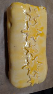 Beef Wellington enveloppé de pâte, doré au jaune d'œuf et décoré de flocons de neige découpés