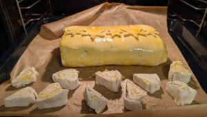 Beef Wellington sur une plaque couverte de papier sulfurisé, prêt à cuire, avec des spirales de chutes de pâte à côté
