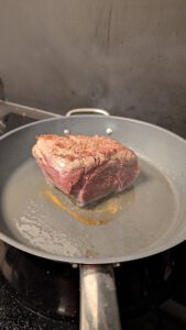 Filet de bœuf en train de saisir dans une poêle très chaude