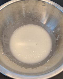 Glaçage lisse et blanc au sucre glace et au jus de citron dans un bol en inox