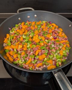 Dés de pancetta, oignon rouge, carotte et céleri qui cuisent dans une sauteuse large pour le soffritto